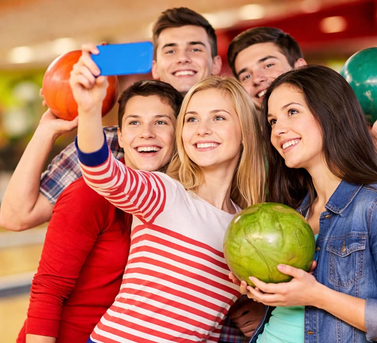 Teens taking a selfie with bowling balls at Rowlett Bowl-A-Rama