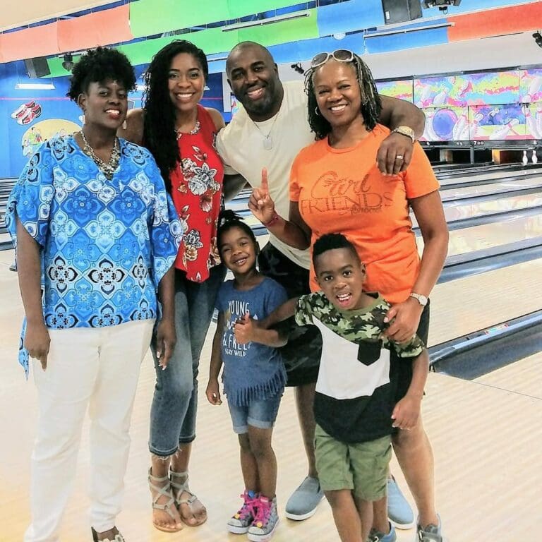 A family smiling together on the lanes at Rowlett Bowl-A-Rama