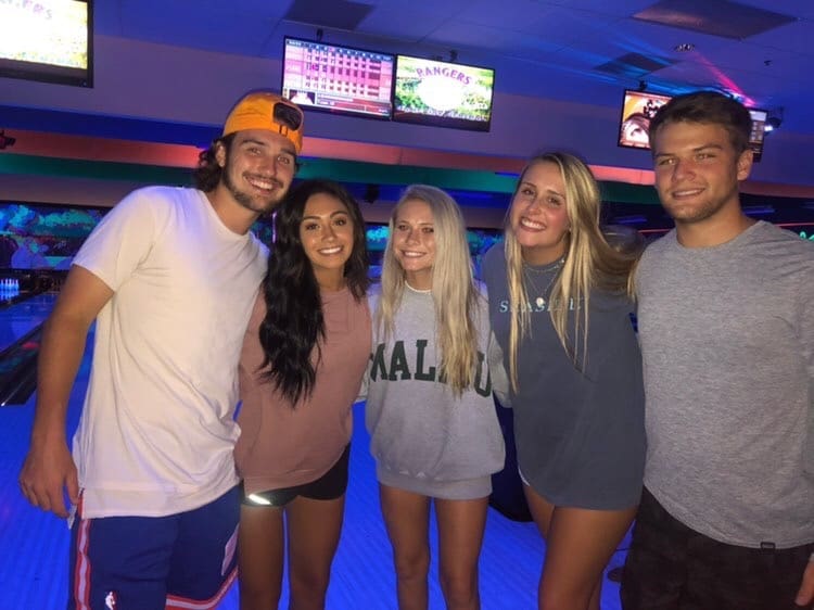 Friends smiling during Glow Bowling at Rowlett Bowl-A-Rama