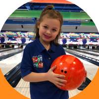 Young bowler in a Bowl-A-Rama shirt holding a bowling ball